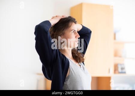 Eine junge Frau, die in einem Raum steht und nachdenkt Stockfoto