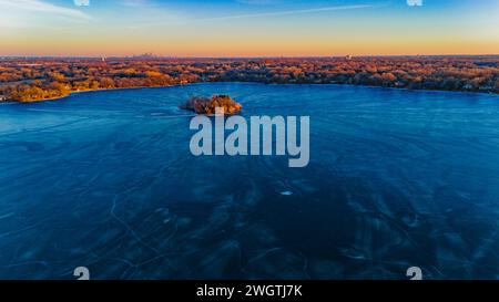 Eine Luftlinie vom Bass Lake, einem See in den Vororten von Minneapolis an einem späteren Winternachmittag. Stockfoto