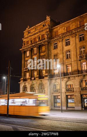 Die Straßenbahn fährt vor dem Gebäude Stockfoto