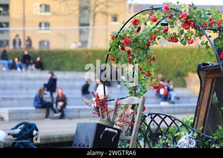 Rosen auf einem Lastkahn auf dem Regents Canal mit Central St Martins am Granary Square dahinter, am Kings Cross in North London, Großbritannien Stockfoto