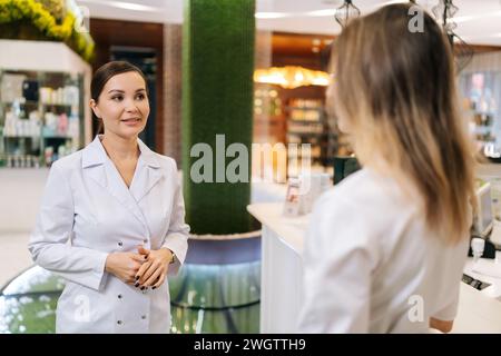 Zwei Ärzte stehen auf dem Krankenhauskorridor und diskutieren die Patientendiagnose. Junge Ärztin beratende Kollegin im Sitzungssaal. Stockfoto