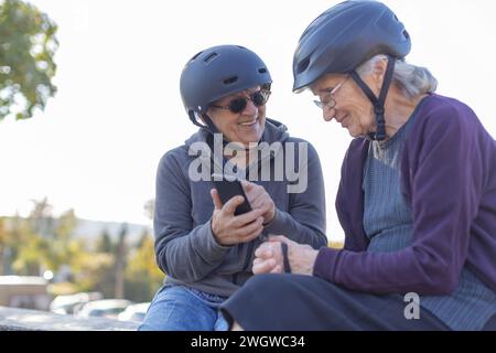 Zwei ältere Damen sitzen mit Fahrradhelmen Stockfoto