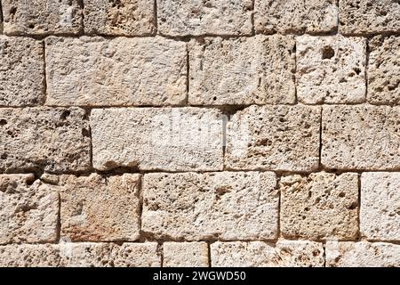 Ein Hintergrund mit einer italienischen Wand aus alten strukturierten Tuffblöcken Stockfoto
