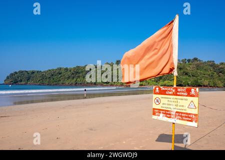 Agonda, Goa, Indien, Meereslandschaft mit einer Halbinsel und einer orangefarbenen Flagge am Sandstrand, nur Editorial. Stockfoto