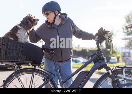 Eine ältere Frau und ihr Hund auf dem Fahrrad Stockfoto
