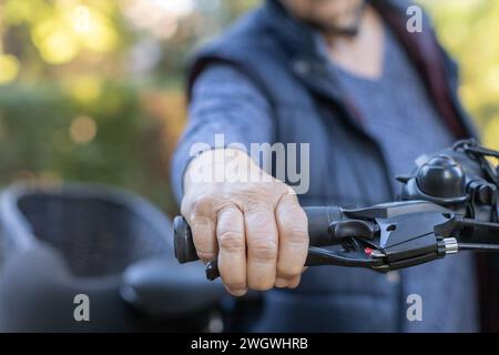 Die Hand älterer Frauen am Fahrradgriff Stockfoto