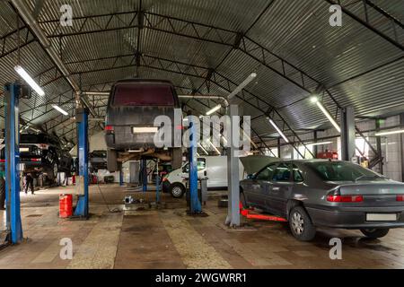 Autos im Kfz-Reparaturzentrum. Moderne Autoreparaturstation mit einer großen Anzahl von Aufzügen und spezieller Ausrüstung für Diagnose und Service Stockfoto