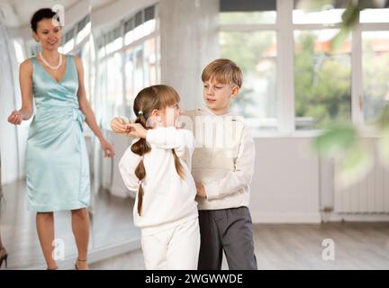 Tween Junge und Mädchen, die Walzer zu zweit in der Tanzhalle spielen Stockfoto