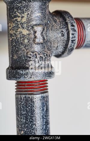 Rohrverschraubung aus rostigem Metall mit rotem Dichtmittel – Makrotextur in Nahaufnahme Stockfoto
