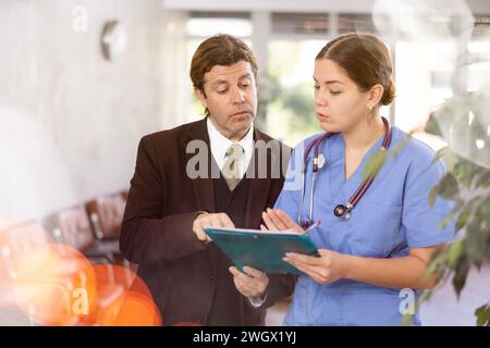 Aufmerksame Ärztin verschreibt Tests an Patienten der Klinik, um den Gesundheitszustand zu überprüfen Stockfoto