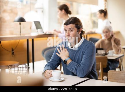 Ruhiger Mann, der Ruhe und Frieden allein in einem gemütlichen Café genießt Stockfoto