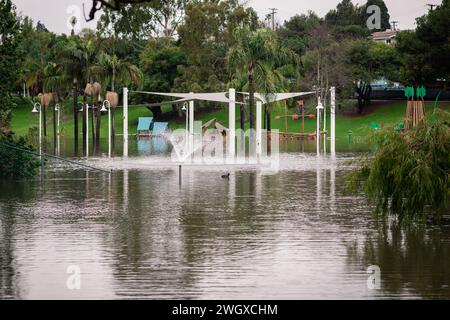 Unterer Spielplatz und großer Teich im Polliwog Park, überflutet vom Regen in Manhattan Beach, CA Stockfoto