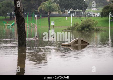 Unterer Spielplatz und großer Teich im Polliwog Park, überflutet vom Regen in Manhattan Beach, CA Stockfoto