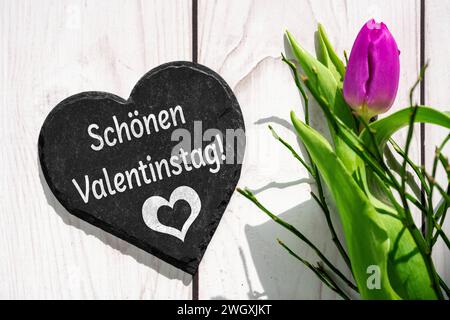 6. Februar 2024: Happy Valentine s Day, Greeting on a Heart next a pink Tulpe FOTOMONTAGE *** schöner Valentinstag, Gruß auf einem Herz neben einer rosa Tulpe FOTOMONTAGE Stockfoto