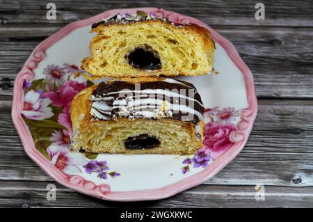 Gebackenes dänisches Gebäck, gefüllt mit brauner Zartbitterschokolade und weißer Schokoladensauce, süßer Backteig, der im Ofen mit Mehl, Zucker und gebacken wird Stockfoto