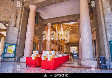 CREMONA, ITALIEN - 6. APRIL 2022: Die Steinhalle der Galleria XXV Aprile mit Bücherständen und hohen massiven Steinsäulen, Cremona, Italien Stockfoto