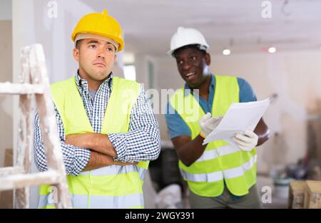 Porträt eines verwirrten Baumeisters und wütenden Baumeisters auf der Baustelle Stockfoto