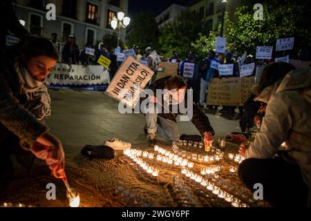 Madrid, Spanien. Februar 2024. Ein Demonstrant zündet während einer Kundgebung Kerzen an. Das Madrider Stadtteil Lavapies hat der einjährigen Tragödie von El Tarajal gedenken, bei der in den frühen Morgenstunden des 6. Februar 2014 mehr als 250 Menschen subsaharischen Ursprungs versuchten, Ceuta über den Strand von El Tarajal zu erreichen, und von der Zivilgarde abgestoßen wurden. 15 Menschen starben und 23 weitere wurden nach Marokko zurückgebracht. Quelle: SOPA Images Limited/Alamy Live News Stockfoto