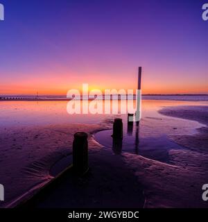 Selsey, Vereinigtes Königreich - 19. Februar 2023: Sonnenuntergang über West Wittering Beach, West Sussex, Vereinigtes Königreich Stockfoto