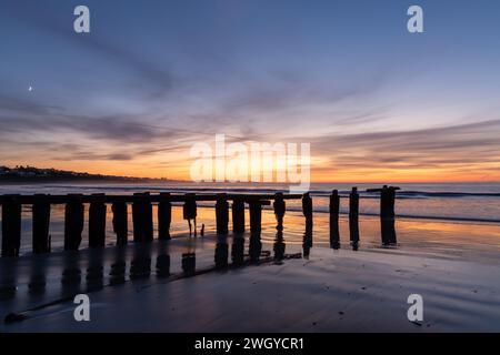 Ein Sonnenaufgang am Strand von Victor Harbor über den Erosion Groynes in South Australia am 11. September 2023 Stockfoto