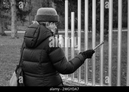 The Trustees DeCordova Sculpture Park and Museum - Lincoln, MA. Eine Frau spielt eine Aluminium klingende Barskulptur mit dem Titel The Musical Fence von Paul Matis Stockfoto