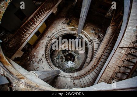 Blick von oben auf die alte, im Vintage-Stil dekorierte Wendeltreppe in einem verlassenen Herrenhaus. Stockfoto