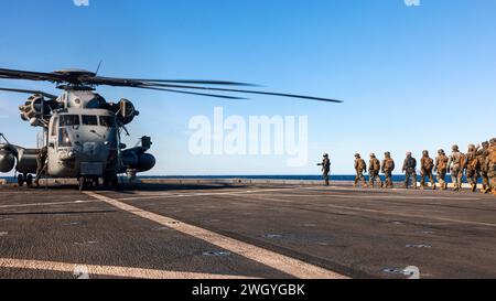 Ein Hubschrauberbesatzungschef des U.S. Marine Corps, der der Marine Medium Tiltrotor Squadron (VMM) 165 (verstärkt), 15. Marine Expeditionary Unit, zugeteilt ist, führt die Marines zu einem CH-53E Super Hallion, bevor sie am 11. Januar 2024 vom Amphibien-Transportdock USS Somerset (LPD 25) im Pazifischen Ozean starten. Die 15. MEU ist derzeit an Bord der Boxer Amphibious Ready Group, die integrierte Trainings- und Routineoperationen in der 3. US-Flotte durchführt. (Foto des U.S. Marine Corps von CPL. Aidan Hekker) Stockfoto