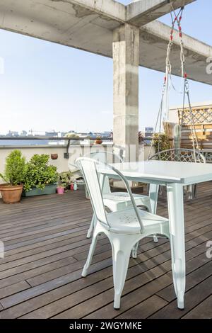 Eine urbane Terrasse mit Pflanzen und ein Metalltisch mit passenden Stühlen Stockfoto