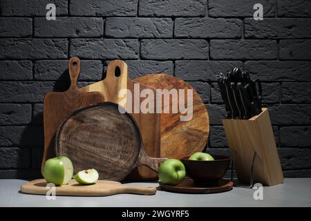 Schneidebretter aus Holz, Äpfel und Messer auf grauem Tisch Stockfoto