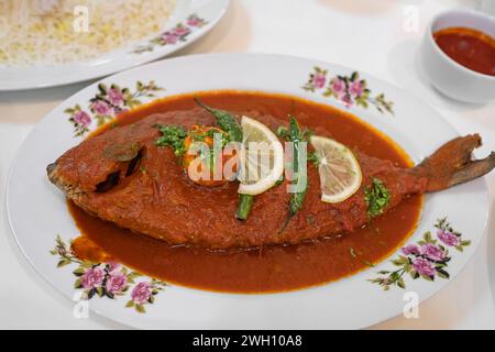 Maragat Zubaidi Fischgericht mit Tomatensauce auf einem Teller, Seer Fischcurry, traditionelles Fischcurry, spezielles Gericht. Silberpommelfische mit rotem Sause trad Stockfoto