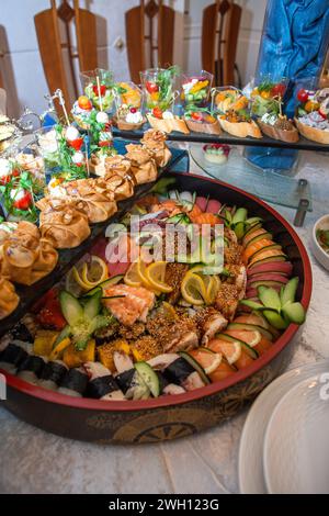 Eine Auswahl an Vorspeisen wie Sushi, Bruschetta und Häppchen auf einer Platte. Ideal für elegante Versammlungen oder Catering-Veranstaltungen. Isoliert auf einem wh Stockfoto