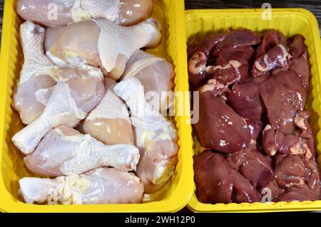 Hähnchenschenkel roh Hinterviertel mit Haut und Knochen und frische, nicht gekochte Hühnerleber, Muskelmagen und Herzen, selektiver Fokus frischer Leber, gi Stockfoto