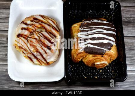 Dänisches Gebäck gefüllt und garniert mit brauner dunkler Schokolade, weißer Schokolade, Karamellsauce, süßem Backteig im Ofen mit Mehl, Zucker und Stockfoto