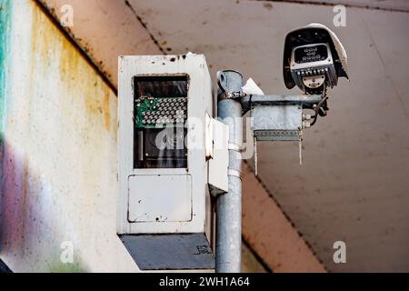 Nahaufnahme von Verkehrs- und Geschwindigkeitskontrollkameras auf der Straße, gegen altes weißes Dach einer schmutzigen und fleckigen Fahrzeugbrücke, Überwachung und Überwachung von s Stockfoto