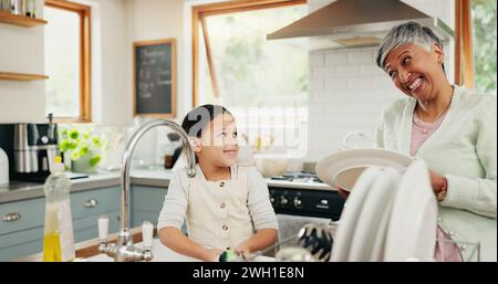 Glücklich, Großmutter und Kind waschen Geschirr mit Hilfe, unterrichten und lernen von einer Seniorin. Lächeln, Unterstützung und eine ältere Frau und ein Mädchen Stockfoto