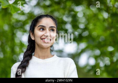 Eine strahlende junge Indianerin mit einem wunderschönen Lächeln, die freudig durch die Stadt spaziert, glücklich und zufrieden von ihrer Stadtbesichtigung. Stockfoto