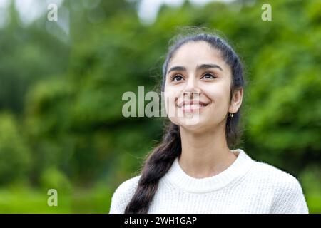 Eine fröhliche Indianerin, die durch die Stadt reist und ihre Zufriedenheit und Freude ausdrückt und den städtischen Tourismus und kulturellen Austausch repräsentiert. Stockfoto