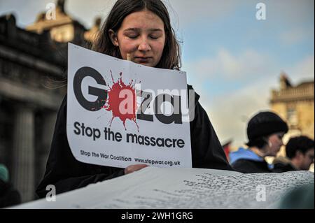 Edinburgh, Großbritannien. Januar 2024. Ein Demonstrant hält während der Demonstration ein Plakat. Pro-Palestine-Anhänger hielten eine Kundgebung in Edinburgh am Mound ab, wo die Menge den Rednern zuhörte und Unterstützung zeigte. Während der Kundgebung eine Liste, die auf Stoff geschrieben wurde, mit einer kleinen Liste unschuldiger Zivilisten, die im Konflikt von israelischen Streitkräften getötet wurden. Die Kundgebung wurde zu einem marsch, der am Mound begann und dann die Princes Street hinunter und dann auf den Charlotte Square ging, bevor sie aus Bute House, dem Heim des ersten schottischen Ministers Yousaf Humza, endete. Die Unterstützer drängten die Stockfoto