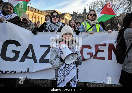 Edinburgh, Großbritannien. Januar 2024. Ein kleines Kind steht vor der Menschenmenge, bevor es nach dem Verlassen des Hügels weiter zur Princes Street marschierte. Pro-Palestine-Anhänger hielten eine Kundgebung in Edinburgh am Mound ab, wo die Menge den Rednern zuhörte und Unterstützung zeigte. Während der Kundgebung eine Liste, die auf Stoff geschrieben wurde, mit einer kleinen Liste unschuldiger Zivilisten, die im Konflikt von israelischen Streitkräften getötet wurden. Die Rallye wurde zu einem marsch, beginnend am Mound, über die Princes Street und dann auf den Charlotte Square, bevor sie aus Bute House, ho, endete Stockfoto