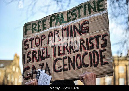 Edinburgh, Großbritannien. Januar 2024. Ein Demonstrant hält während der Demonstration ein Plakat. Pro-Palestine-Anhänger hielten eine Kundgebung in Edinburgh am Mound ab, wo die Menge den Rednern zuhörte und Unterstützung zeigte. Während der Kundgebung eine Liste, die auf Stoff geschrieben wurde, mit einer kleinen Liste unschuldiger Zivilisten, die im Konflikt von israelischen Streitkräften getötet wurden. Die Kundgebung wurde zu einem marsch, der am Mound begann und dann die Princes Street hinunter und dann auf den Charlotte Square ging, bevor sie aus Bute House, dem Heim des ersten schottischen Ministers Yousaf Humza, endete. Die Unterstützer drängten die Stockfoto