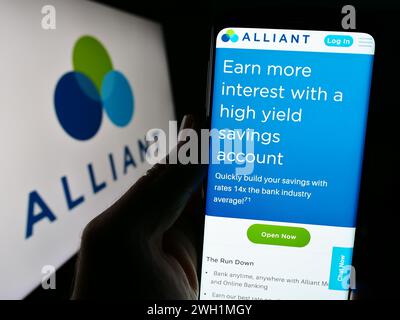 Person, die ein Mobiltelefon hält, mit Webseite des US-Finanzinstituts Alliant Credit Union vor dem Logo. Konzentrieren Sie sich auf die Mitte des Telefondisplays. Stockfoto