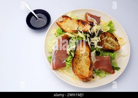 Ein Teller mit grünem Blattsalat, parmaschinken und Parmesankäse Stockfoto