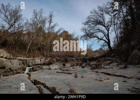 Das halbtrockene Flussbett des Flusses Ter am Montesquiu in der Provinz Barcelona im Norden Kataloniens vorbei. Der Ter ist ein katalanischer Fluss, der in den Pyrenäen entspringt und in das Mittelmeer mündet. Die Dürre, unter der Katalonien seit 2021 leidet, hat dazu geführt, dass die Flussrate und die ökologische Qualität der Flüsse zurückgegangen sind, was sich negativ auf die biologische Vielfalt des Gebiets auswirkt. zwar bleiben die Ableitungen von Kläranlagen und Industriezweigen in den Fluss gleich, aber die Schadstoffe können nicht in Wasser und verdünnt werden Stockfoto