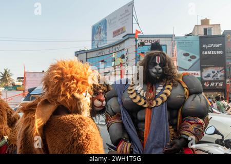 Hassan, Karnataka, Indien – 10. Januar 2023: Straßenkünstler, die als hinduistische mythologische Charaktere gekleidet sind, unterhalten die Menge während des Shobha Yatra f Stockfoto