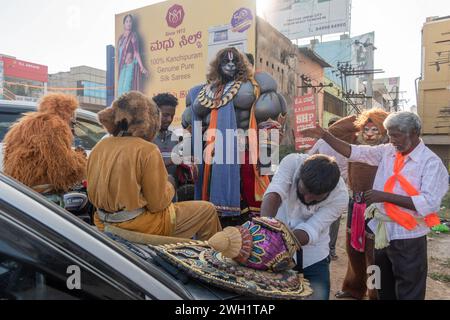 Hassan, Karnataka, Indien – 10. Januar 2023: Straßenkünstler, die als hinduistische mythologische Charaktere gekleidet sind, unterhalten die Menge während des Shobha Yatra f Stockfoto