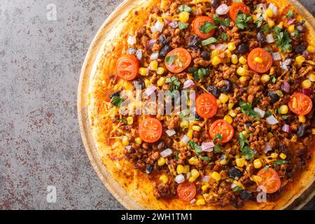 Heiße Tex Mex Taco Pizza mit Hackfleisch, Salsa, Cheddar Käse und mexikanischen Gewürzen, die auf einem Holzbrett auf dem Tisch liegen. Horizontale Draufsicht von ab Stockfoto