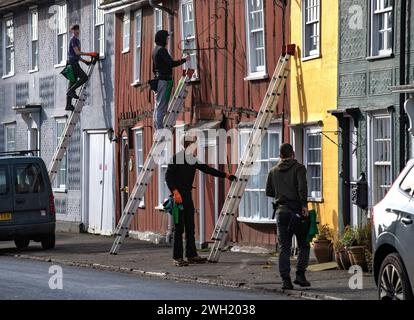 Thaxted, England Gb Februar 2024. Thaxted Essex UK Window Cleaners at Work 7 Feb 2024 Fensterreiniger beschäftigt bei der Arbeit in Thaxted Essex, Großbritannien. Die meisten Häuser in Thaxted stammen aus dem 14. Und 15. Jahrhundert und sind mit Fachwerk versehen. Jedes Haus hat eine andere, aber traditionelle Farbe. Da die Häuser der Klasse 11 unter Denkmalschutz stehen, können die Fenster nicht verändert werden, sodass das lokale Fensterputzteam viel Arbeit an den kleinen Scheiben aus antikem Glas zu erledigen hat. Foto: BRIAN HARRIS/Alamy Live News Stockfoto