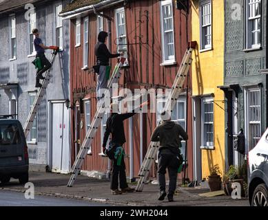 Thaxted, England Gb Februar 2024. Thaxted Essex UK Window Cleaners at Work 7 Feb 2024 Fensterreiniger beschäftigt bei der Arbeit in Thaxted Essex, Großbritannien. Die meisten Häuser in Thaxted stammen aus dem 14. Und 15. Jahrhundert und sind mit Fachwerk versehen. Jedes Haus hat eine andere, aber traditionelle Farbe. Da die Häuser der Klasse 11 unter Denkmalschutz stehen, können die Fenster nicht verändert werden, sodass das lokale Fensterputzteam viel Arbeit an den kleinen Scheiben aus antikem Glas zu erledigen hat. Foto: BRIAN HARRIS/Alamy Live News Stockfoto