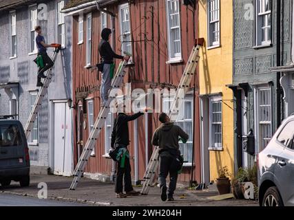 Thaxted, England Gb Februar 2024. Thaxted Essex UK Window Cleaners at Work 7 Feb 2024 Fensterreiniger beschäftigt bei der Arbeit in Thaxted Essex, Großbritannien. Die meisten Häuser in Thaxted stammen aus dem 14. Und 15. Jahrhundert und sind mit Fachwerk versehen. Jedes Haus hat eine andere, aber traditionelle Farbe. Da die Häuser der Klasse 11 unter Denkmalschutz stehen, können die Fenster nicht verändert werden, sodass das lokale Fensterputzteam viel Arbeit an den kleinen Scheiben aus antikem Glas zu erledigen hat. Foto: BRIAN HARRIS/Alamy Live News Stockfoto