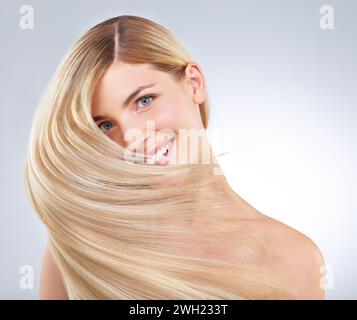 Haarpflege, Shake und Porträt von glücklicher Frau, Schönheit oder Make-up isoliert auf weißem Studiohintergrund. Gesicht, Lächeln und Frisur des blonden Models in Stockfoto